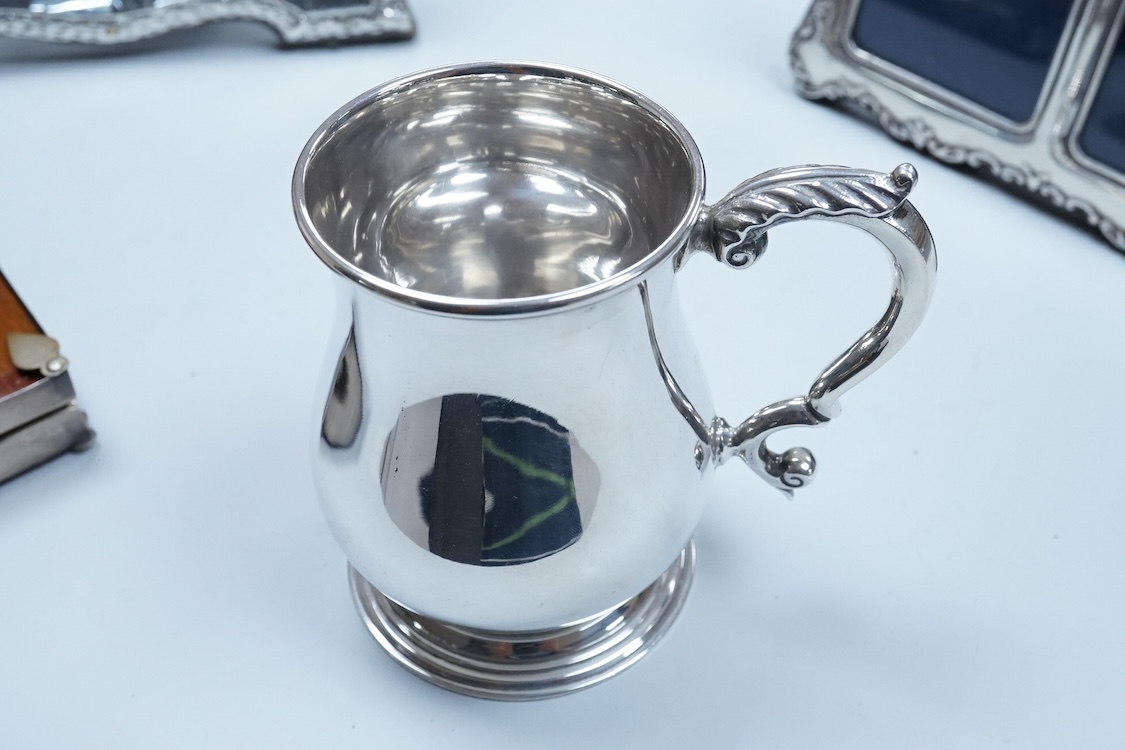 An Elizabeth II silver baluster christening mug, Wakely & Wheeler, London, 1965, with engraved inscription to the base, 10cm, together with two modern silver mounted photograph frames including a double and one other met